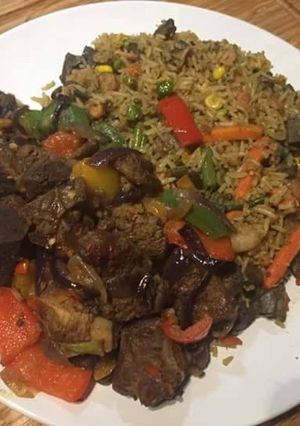 A picture of Jollof rice with carrots,green bell pepper.