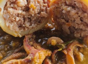 Una foto de Calamares rellenos de langostinos y sepia en salsa de langostinos y crujiente de almendras