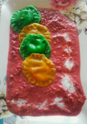 A picture of Sweet ravioli with beet sauce.