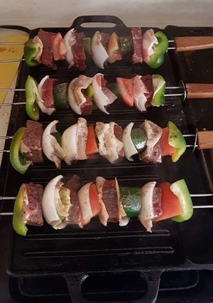 Una foto de Brochetas asadas de carne y vegetales