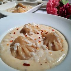 A picture of Momo with white cheesy sauce.