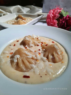 A picture of Momo with white cheesy sauce.