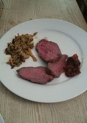 A picture of Roast beef with fried mushrooms and a tomato chutney.