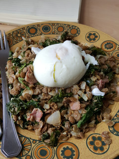 A picture of Warm lentil, bacon and kale salad with poached egg.