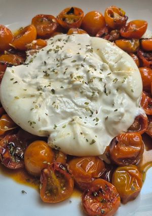 Una foto de Ensalada de Tomate confitados con burrata