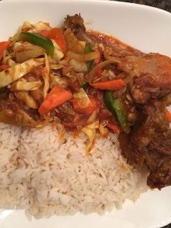 A picture of Ofada rice with chicken and vegetables.