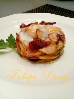 Una foto de Timbal de patatas huevos de codorniz y virutas de ibérico