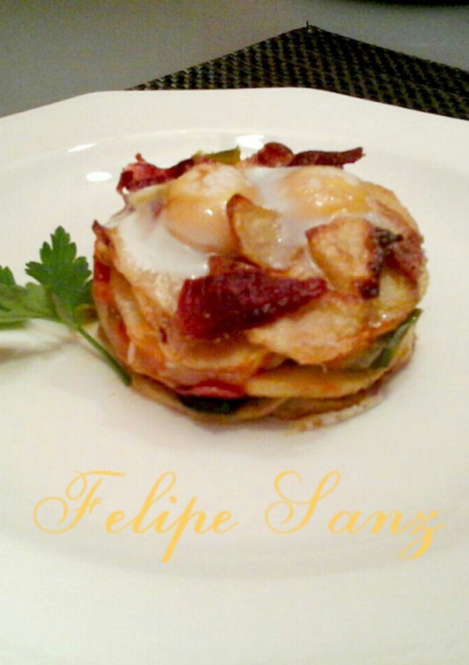 Una foto de Timbal de patatas huevos de codorniz y virutas de ibérico