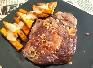 Una foto de Chuletón de ternera a la plancha con patatas rústicas al horno y mayonesa de miso y yakiniku