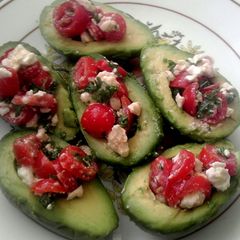 A picture of Tomato salad stuffed avocados.