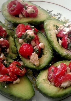A picture of Tomato salad stuffed avocados.