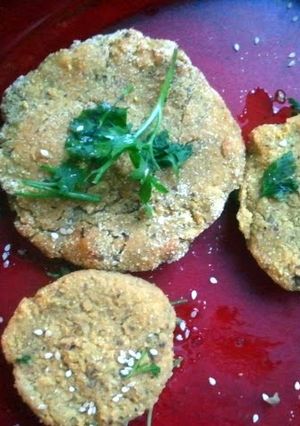 A picture of soy burger with vegetables sesame and parsley..