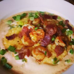 A picture of Shrimp & Cheddar Jalapeño Grits with Cajun cream sauce.
