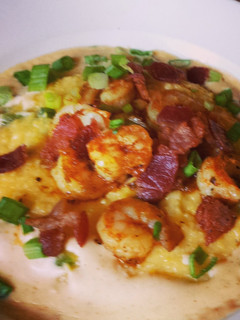 A picture of Shrimp & Cheddar Jalapeño Grits with Cajun cream sauce.