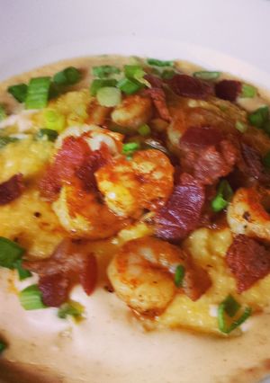 A picture of Shrimp & Cheddar Jalapeño Grits with Cajun cream sauce.