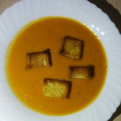 A picture of Cream of tomato Soup with croutones.