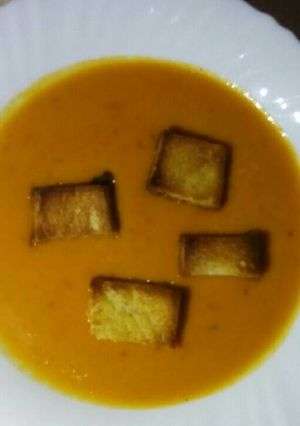 A picture of Cream of tomato Soup with croutones.