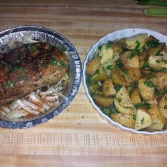 A picture of pork roast tenderloin with roasted potatoes and corn on the cob.