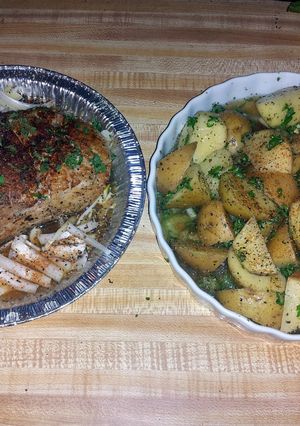A picture of pork roast tenderloin with roasted potatoes and corn on the cob.