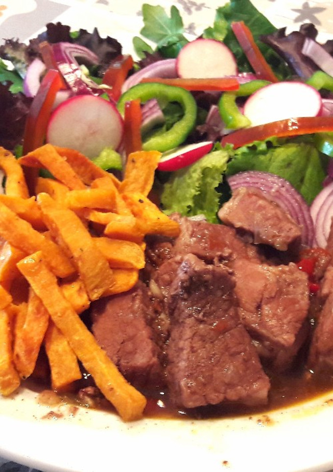 Una foto de Ternera o cerdo al chocolate con batata especiada y ensalada