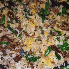 A picture of Sausage, spinach, and rice.