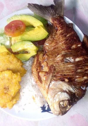 Una foto de Cachama frita con arroz ensalada y tostones