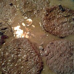 A picture of onions mushrooms and sirloin burgers in gravy.