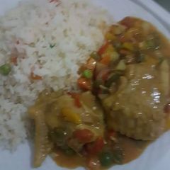 A picture of White rice with chicken sauce.