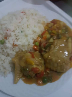 A picture of White rice with chicken sauce.