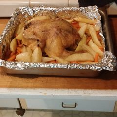 A picture of Roasted chicken with carrots and potatoes.