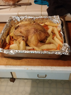 A picture of Roasted chicken with carrots and potatoes.