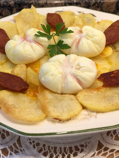 Una foto de Patatas chips, chorizo crujiente picante y huevos flor
