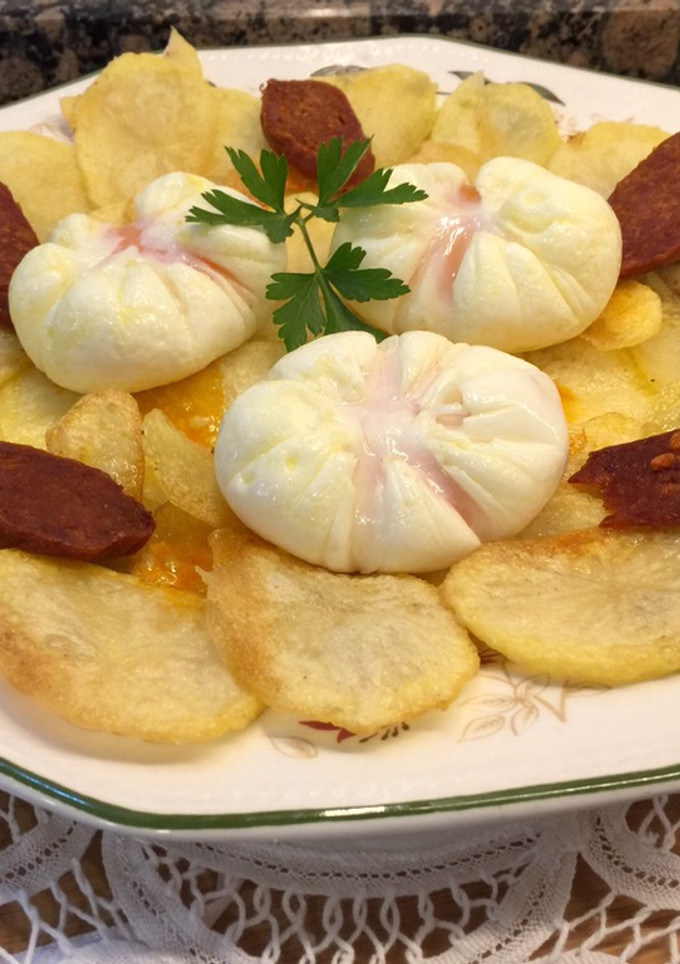 Una foto de Patatas chips, chorizo crujiente picante y huevos flor