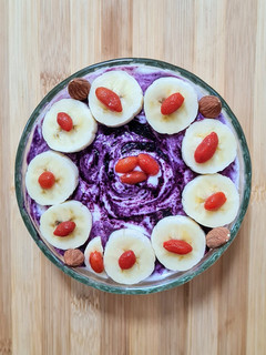 Una foto de Smoothie bowl de banana, quinoa pop sin azúcar, bayas de goji y maqui berry con yogur casero