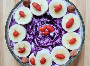 Una foto de Smoothie bowl de banana, quinoa pop sin azúcar, bayas de goji y maqui berry con yogur casero