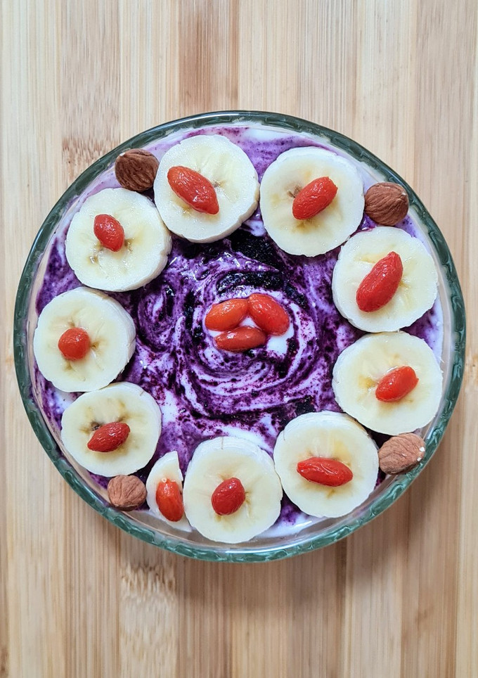 Una foto de Smoothie bowl de banana, quinoa pop sin azúcar, bayas de goji y maqui berry con yogur casero