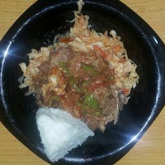 A picture of Beef stew with cabbage fried served with ugali.
