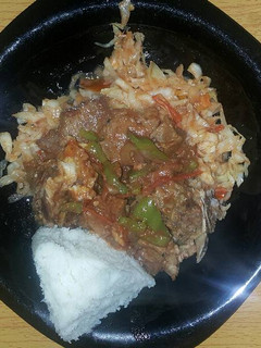 A picture of Beef stew with cabbage fried served with ugali.