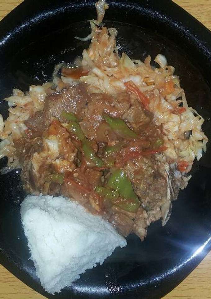 A picture of Beef stew with cabbage fried served with ugali.