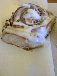 A picture of Professional cinnamon rolls topped with cream cheese icing.