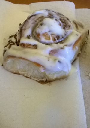 A picture of Professional cinnamon rolls topped with cream cheese icing.