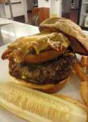 Beef Tender loin burger with pulled pork stuffed onion ring and melted cheddar cheese