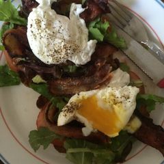 A picture of Avocado toast with poached eggs & bacon.