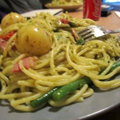 A picture of Pesto Pasta, with potatos, green beans, tomatoes and bacon.