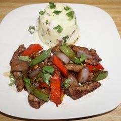 A picture of BEEF LIVER WITH PEPPERS, ONIONS AND GARLIC MASHED POTATOES.