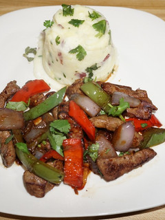 A picture of BEEF LIVER WITH PEPPERS, ONIONS AND GARLIC MASHED POTATOES.
