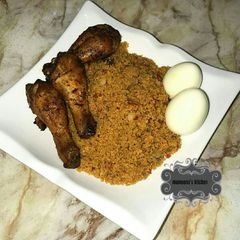 A picture of Jallof cous cous wt grilled chicken drumsticks n boiled eggs.