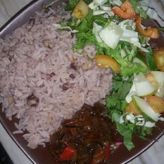 A picture of Boiled rice and beans with onion sauce and salad.