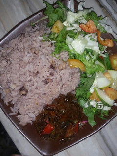 A picture of Boiled rice and beans with onion sauce and salad.