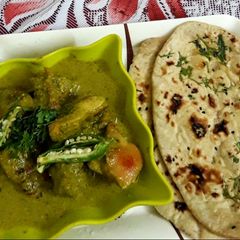 A picture of Green chicken Afghani with butter naan.